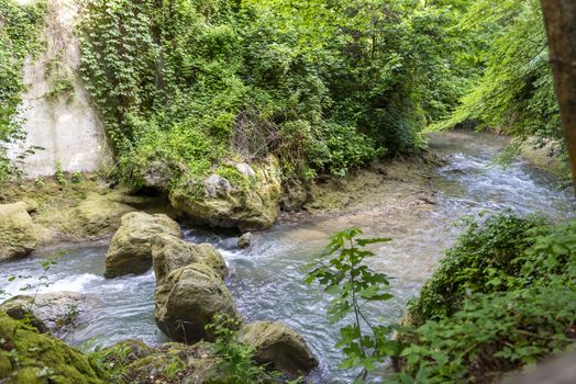 black river that comes from the marmore waterfalls in the middle of nature