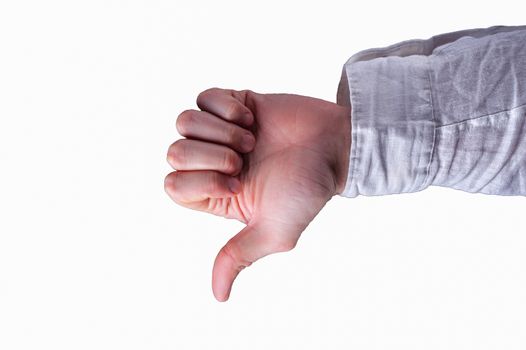 Hand of a man in a white shirt shows thumbs-down sign on isolated white background