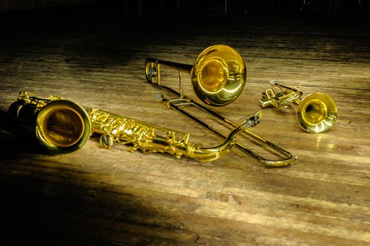 Brass and wind instruments - saxophone, trombone, trumpet on stage with backlight