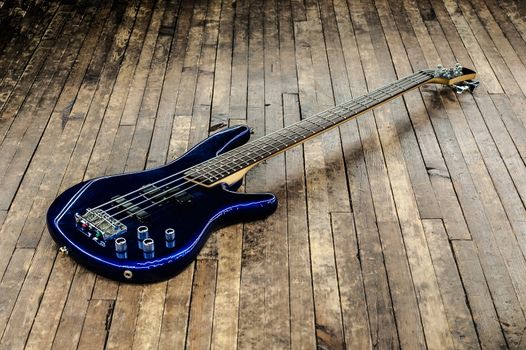 beautiful blue bass guitar on a wooden surface