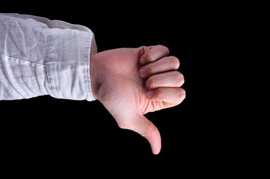 Man hand in a white shirt shows thumbs-down sign on isolated black background