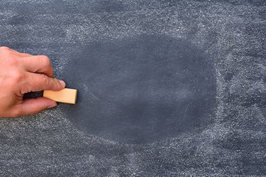 Hand of teacher erasing the blackboard at school.