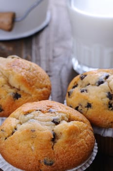 Cupcakes with glass of milk on wooden table.