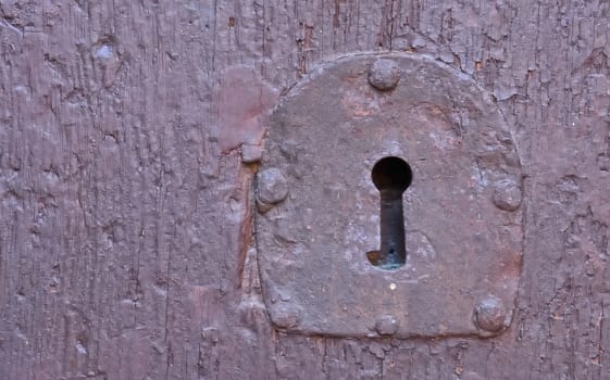 Old metal lock on a wooden door.