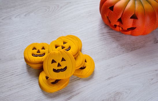 Halloween cookies with pumpkin shape on the kitchen table