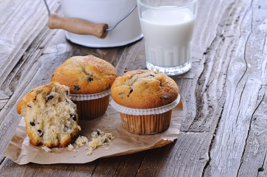 Cupcakes with glass of milk on wooden table.