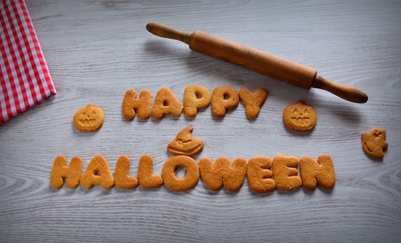 Halloween cookies with pumpkin shape on the kitchen table