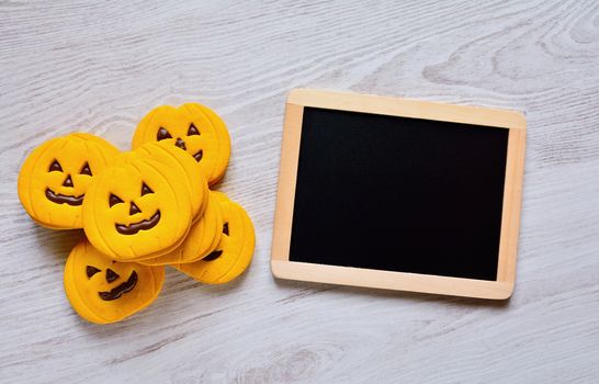 Halloween cookies with pumpkin shape on the kitchen table