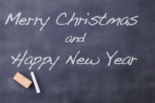 Merry Christmas and Happy New Year congratulation written on blackboard