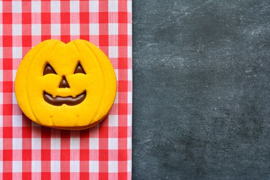 Halloween cookies with pumpkin shape on blackboard.