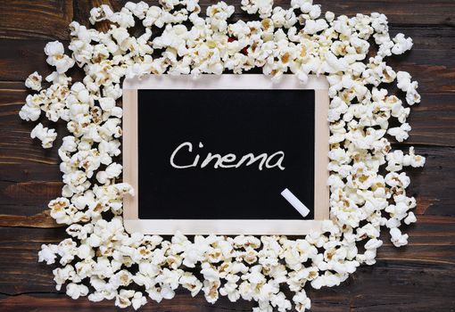 Popcorn and blackboard with the word cinema.
