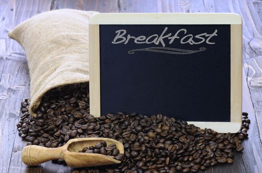 Coffee beans with blackboard on a wooden table.