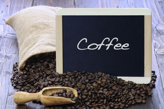 Coffee beans with blackboard on a wooden table.