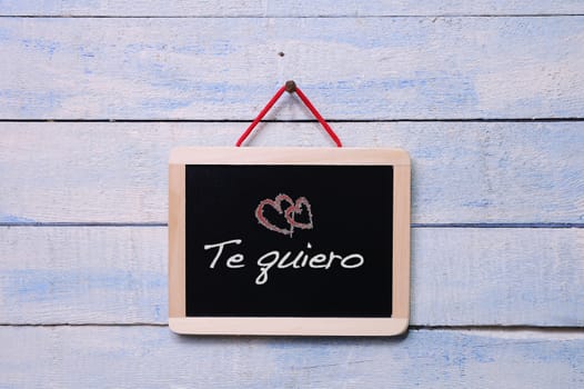 Blackboard on a old wooden wall with phrase, I love you.