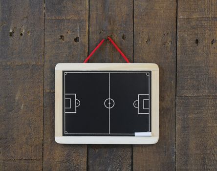 Blackboard hanging on a wall with football field.