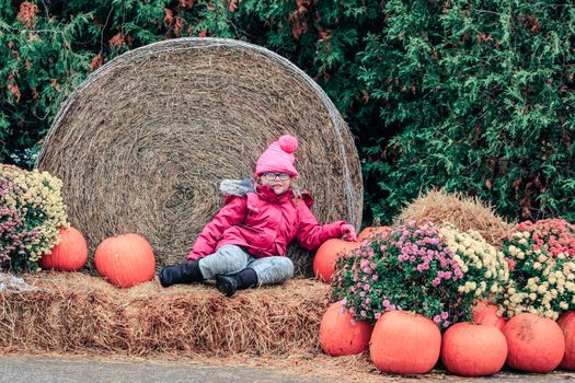 Happy Little Girl in Pumpkin Patch