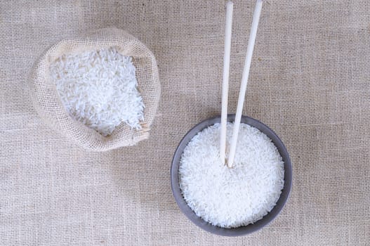 A bowl and a bag of rice on the table.