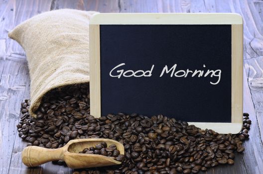 Coffee beans with blackboard on a wooden table.