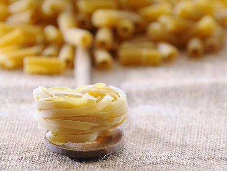 Tagliatelle in a spoon on the kitchen.