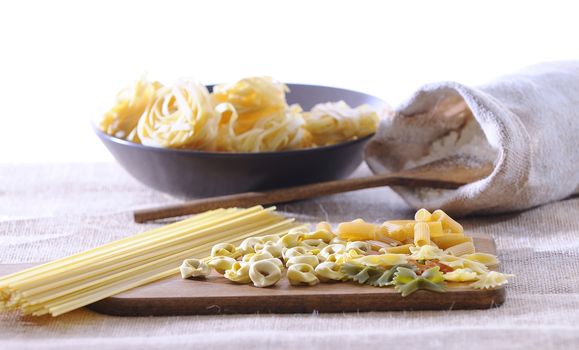 Pasta on a cutting board in a wooden table.