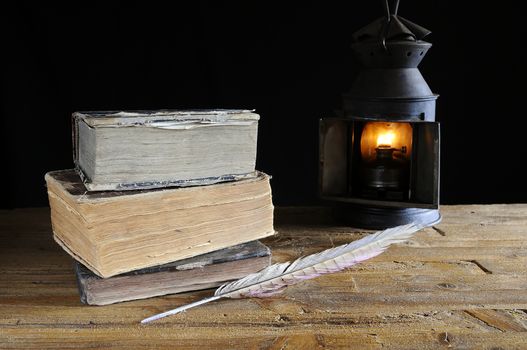 Old books on the table and lantern.