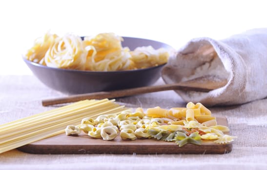 Pasta on a cutting board in a wooden table.