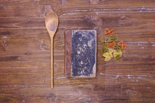 Cookbook over the kitchen table with pasta.