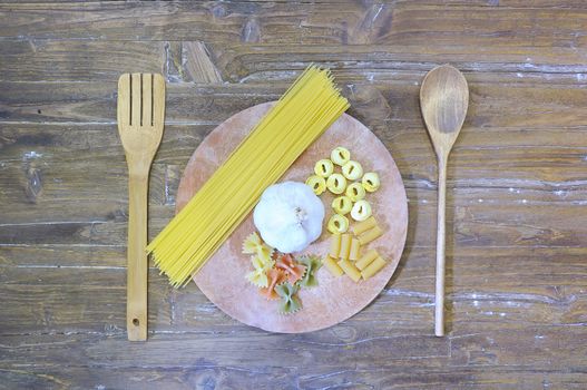 Pasta on a cutting board in a wooden table.