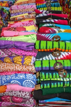 Batik cloth cloth for sale rolled up in market. Balinese art and culture. Close up of rolled colorful sarong. Colorful fabric rolls. Traditional Hindu clothing on Bali island. Sarung ready for sell.