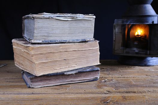 Old books on the table and lantern.