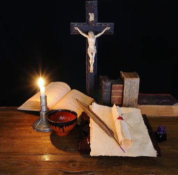 An old book and a crucifix on the table.