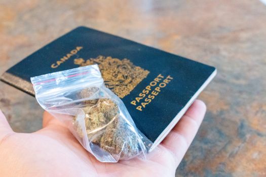 bag of marijuana on a canadian passport. theme of legal recreational cannabis usage