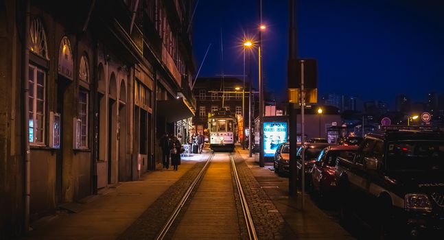 Porto, Portugal - November 30, 2018: Traditional electric tram traveling at night in the streets of the city on a fall day