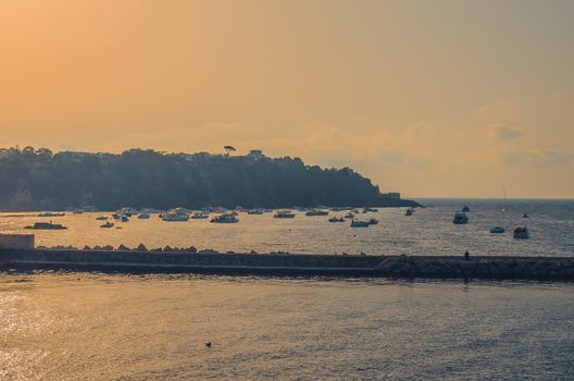 boats in a bay near the island of Procida in the Mediterranean Sea, near the coast of Naples in Italy at sunset