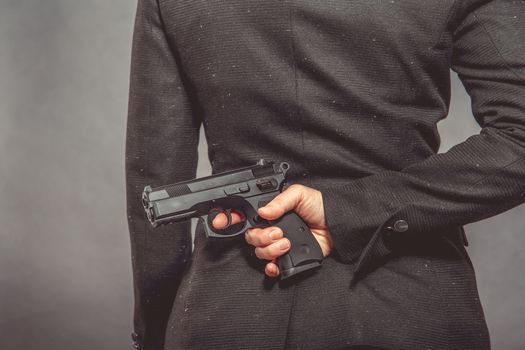 Portrait of woman with gun on blue background.