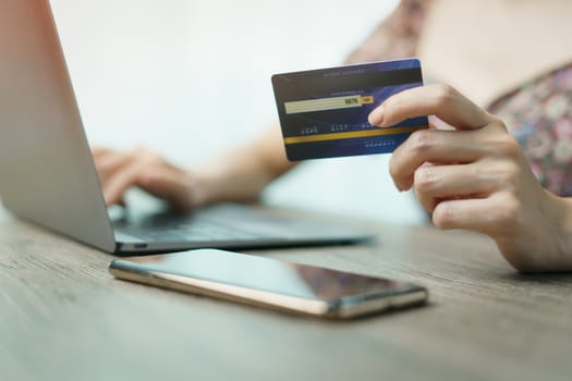 Woman hands holding and using cradit card for shopping online.