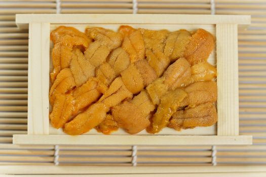 Japanese sea urchin in wooden tray , sushi and sashimi ingredients