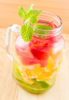 Picture of infused water on wooden background and focus on mint leaf
