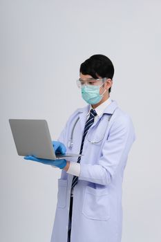 doctor physician practitioner wearing mask with computer & stethoscope on white background. medical professional medicine healthcare concept