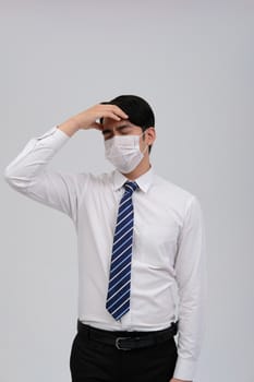 ill businessman man feeling sick, headache wearing protective mask against cold flu virus bacteria infection pollution