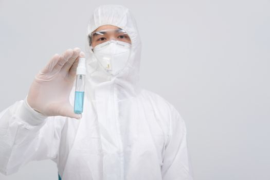 man doctor wearing biological protective uniform suit clothing, mask, gloves with hand alcohol sanitizer dispenser for sanitizing virus bacteria
