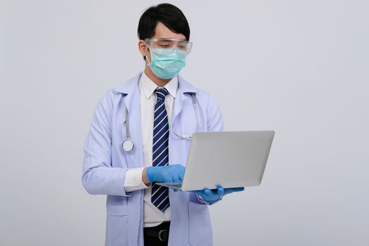 doctor physician practitioner wearing mask with computer & stethoscope on white background. medical professional medicine healthcare concept