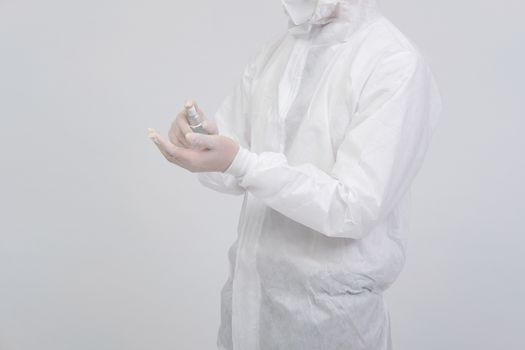 man doctor wearing biological protective uniform suit clothing, mask, gloves with hand alcohol sanitizer dispenser for sanitizing virus bacteria