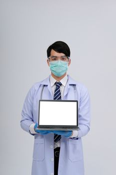 doctor physician practitioner wearing mask with computer & stethoscope on white background. medical professional medicine healthcare concept