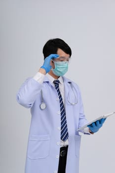 doctor physician practitioner wearing mask with tablet & stethoscope on white background. medical professional medicine healthcare concept