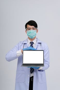 doctor physician practitioner wearing mask with computer & stethoscope on white background. medical professional medicine healthcare concept