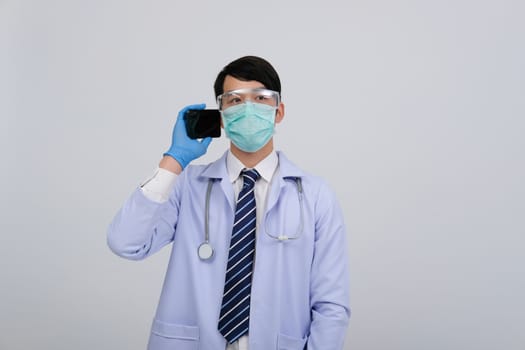 doctor physician practitioner wearing mask with smartphone & stethoscope on white background. medical professional medicine healthcare concept