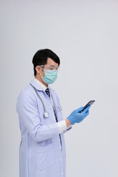 doctor physician practitioner wearing mask with smartphone & stethoscope on white background. medical professional medicine healthcare concept