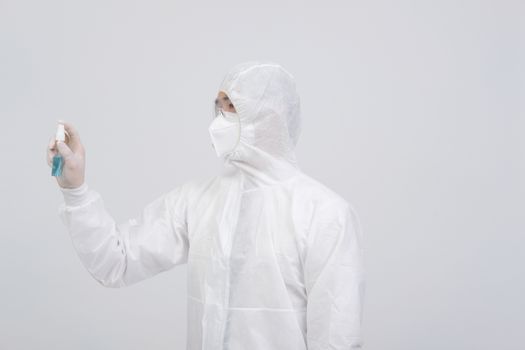man doctor wearing biological protective uniform suit clothing, mask, gloves with hand alcohol sanitizer dispenser for sanitizing virus bacteria