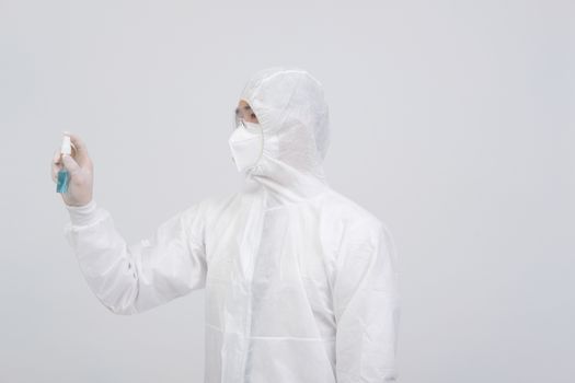 man doctor wearing biological protective uniform suit clothing, mask, gloves with hand alcohol sanitizer dispenser for sanitizing virus bacteria